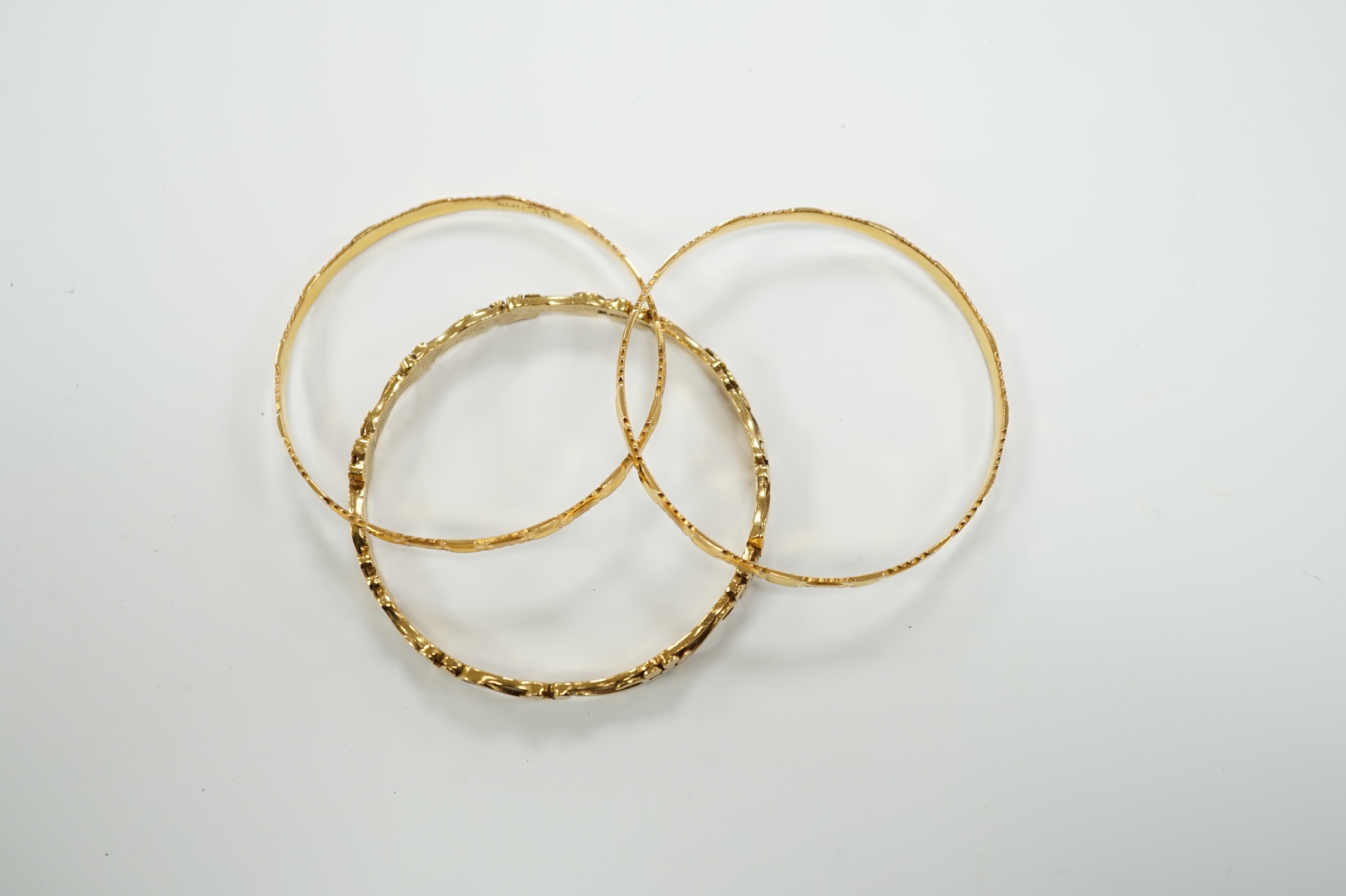 Two 22k bangles, 19.6 grams and a 9ct gold bangle, 20.6 grams.